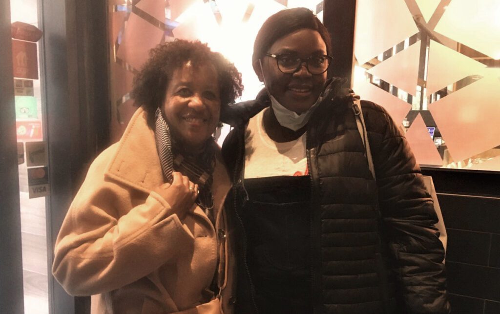 Arlene Campbell and Milka Nyariro smiling and standing together in the entrance of a restaurant.