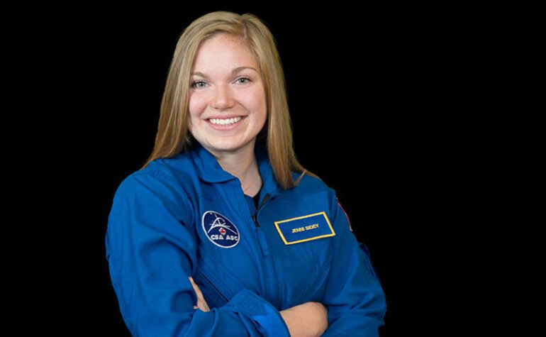 Jenni Sidey-Gibbons wearing Canadian Space Agency coveralls.
