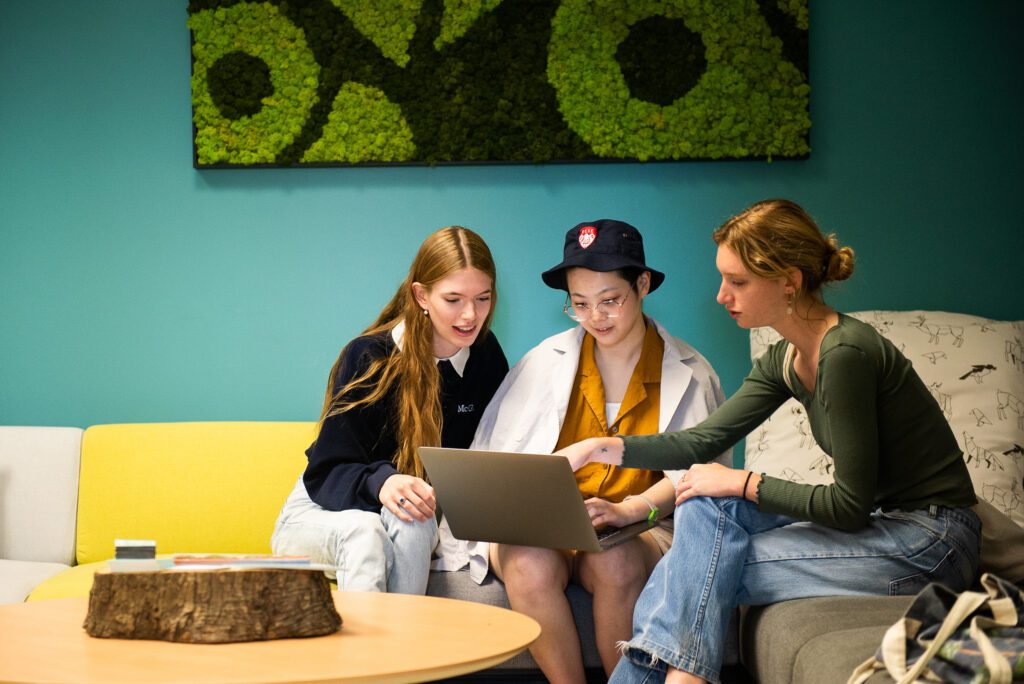 Trois étudiantes regardant un ordinateur portable à l’Annexe Vie saine